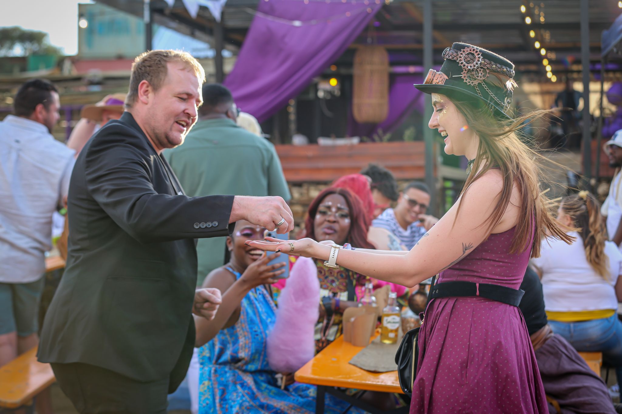 Festival guests in elaborate carnival and steampunk costumes arriving at the venue