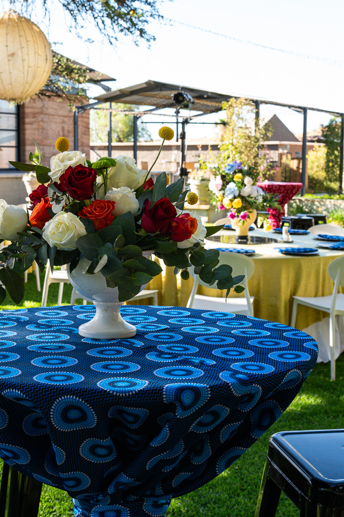 Outdoor corporate event setup with African print linen and floral arrangements