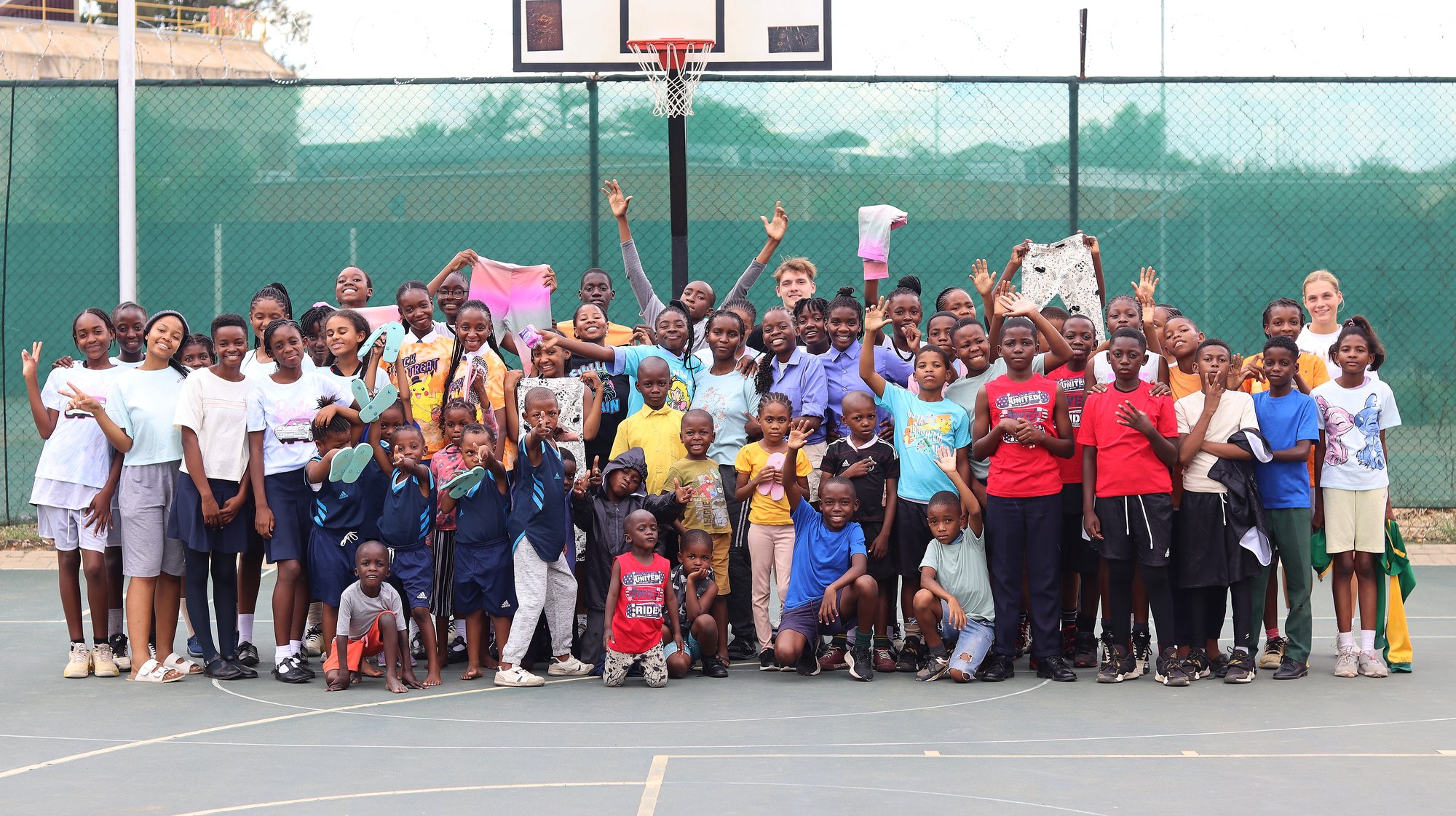A community of children gathered together at an outdoor school programme